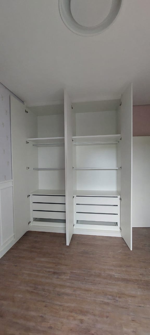 Guarda-roupa branco aberto mostrando prateleiras, cabideiros e gavetas internas