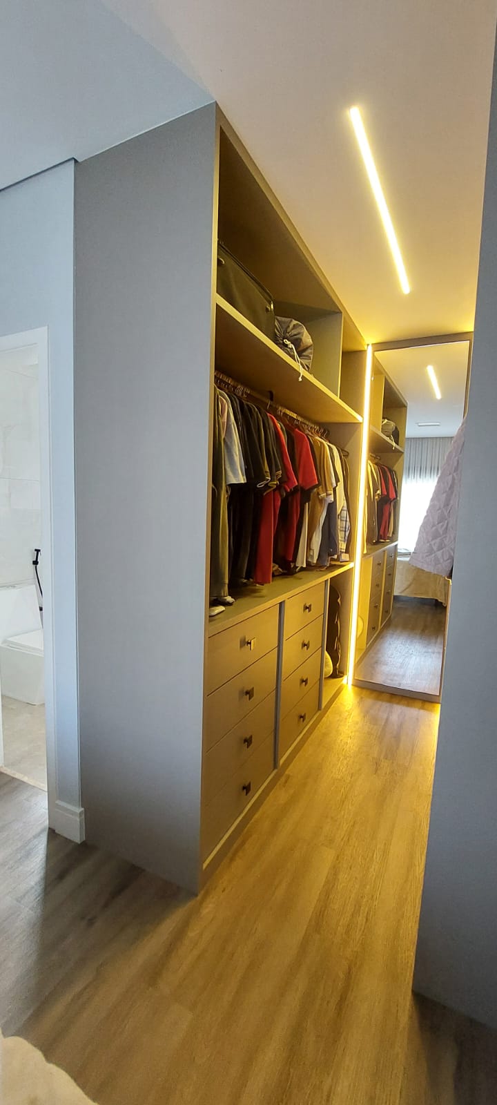 Closet aberto com iluminação LED, cabideiros, gaveteiros e espelho