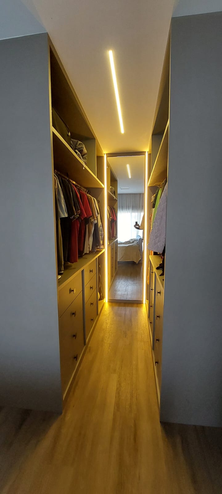 Corredor do closet com LED e espelho ao fundo