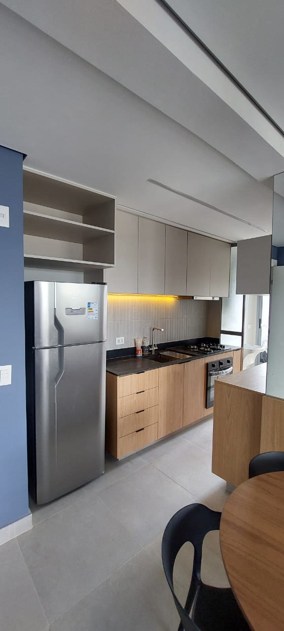 Cozinha compacta com parede azul, armários cinza, madeira clara e LED