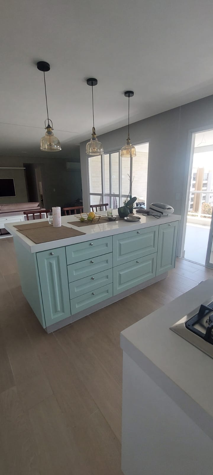 Cozinha clássica com ilha verde menta e pendentes de vidro