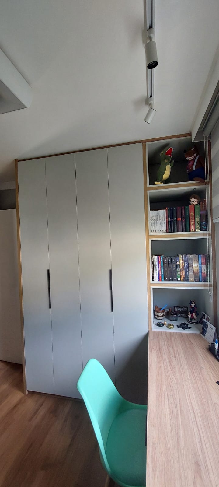 Armário cinza claro com nichos de livros e brinquedos