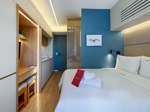 Quarto de studio com parede azul, marcenaria clara e iluminação embutida
